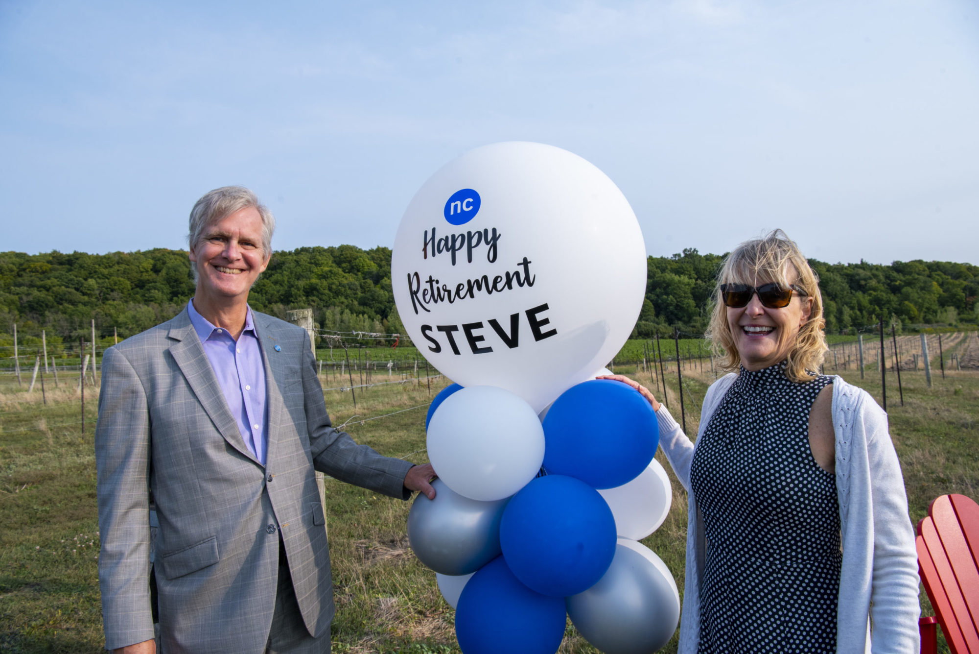 Steve and Kristy Hudson are pictured in the college vineyards with balloons from his retirement celebration.