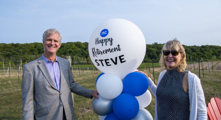 Steve and Kristy Hudson are pictured in the college vineyards with balloons from his retirement celebration.