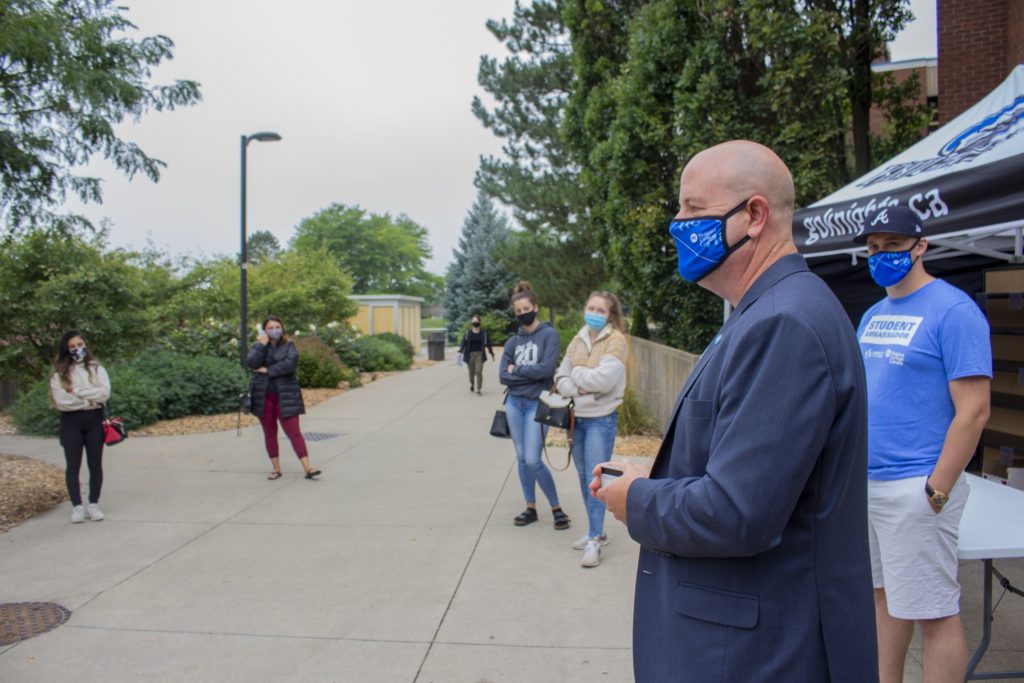 Sean Kennedy stands in front of the Welland campus greeting students