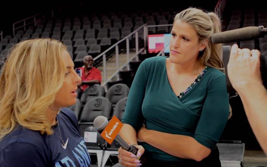 Amy Audibert is pictured with a microphone in hand during an interview