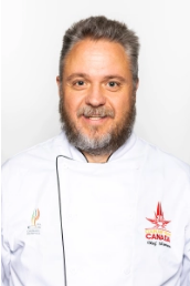 a head shot of chef professor Olaf Mertens  wearinghis Culinary Team Canada whites.